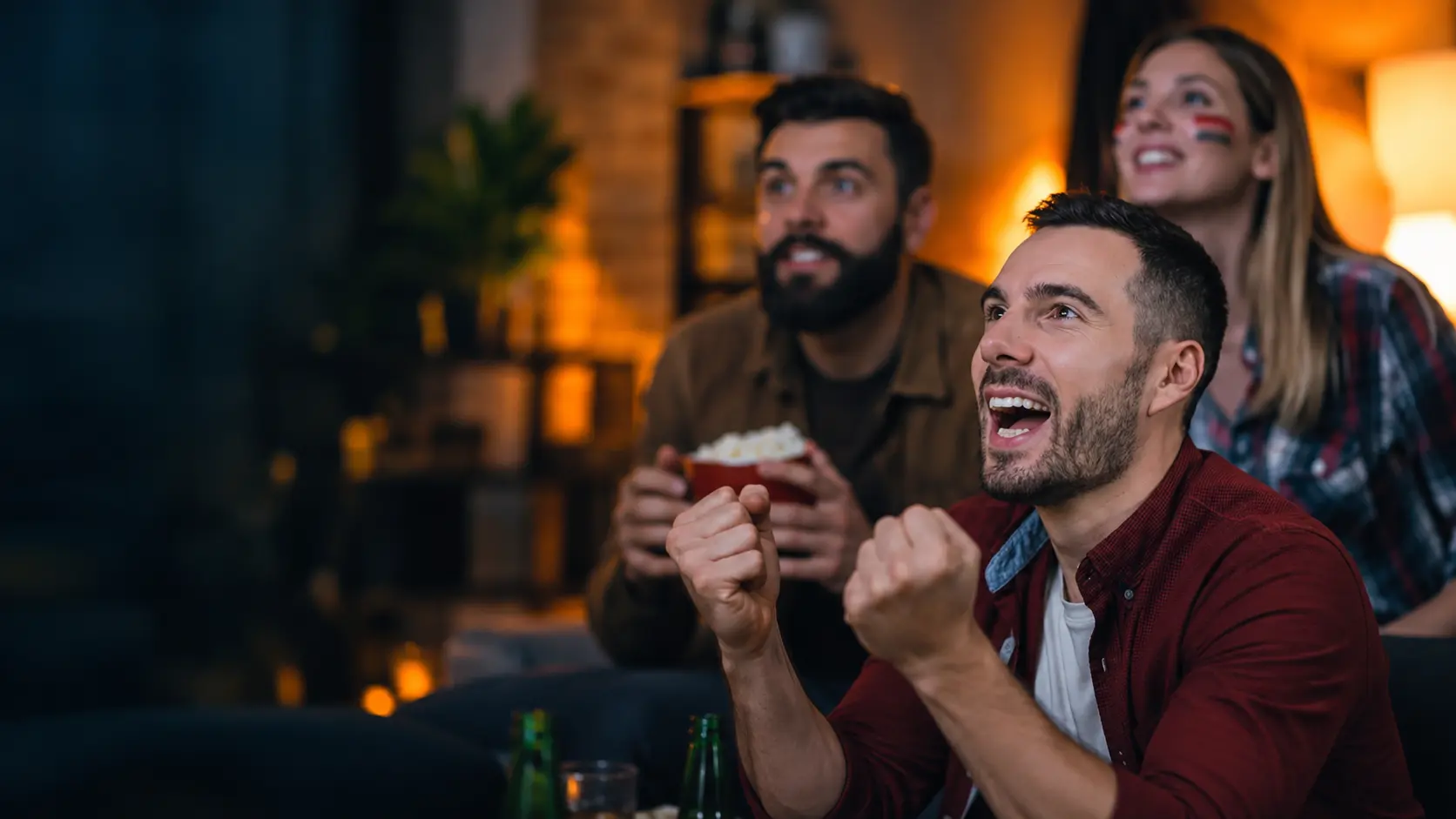 Friends cheering while watching live sport on IPTV UK at home